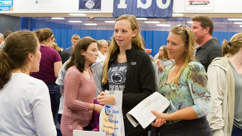 A mother and daughter talk to a college recruiter at the Beaver County College Fair.