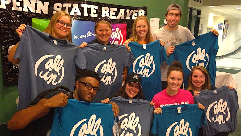 Eight Beaver students pose with their "All In" T-shirts in the Bistro.