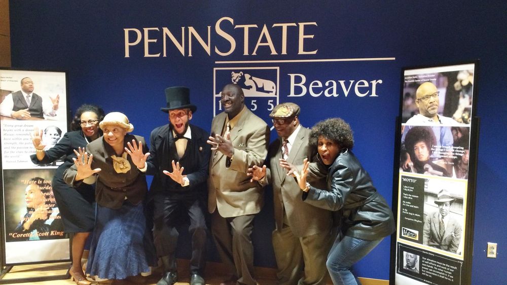 Community members dressed as historical figures in Civil Rights history pose in front of Beaver sign.