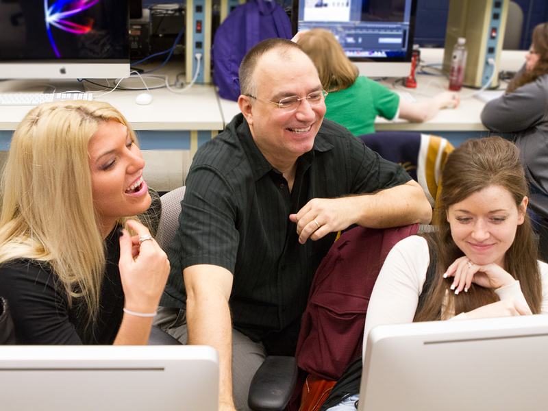 John Chapin and two students look at a computer screen.
