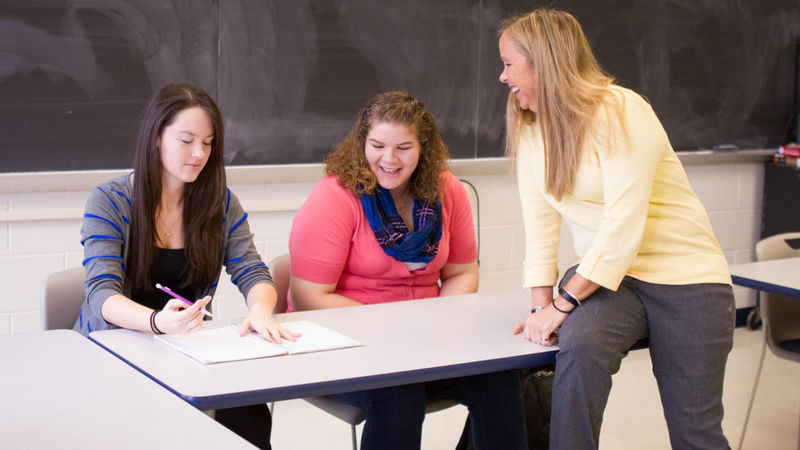 Karen Barr, right, talks with two students in a Penn State Beaver classroom.