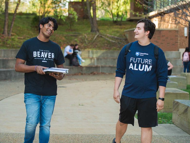 Two male students wearing campus tshirts walk by the bookstore