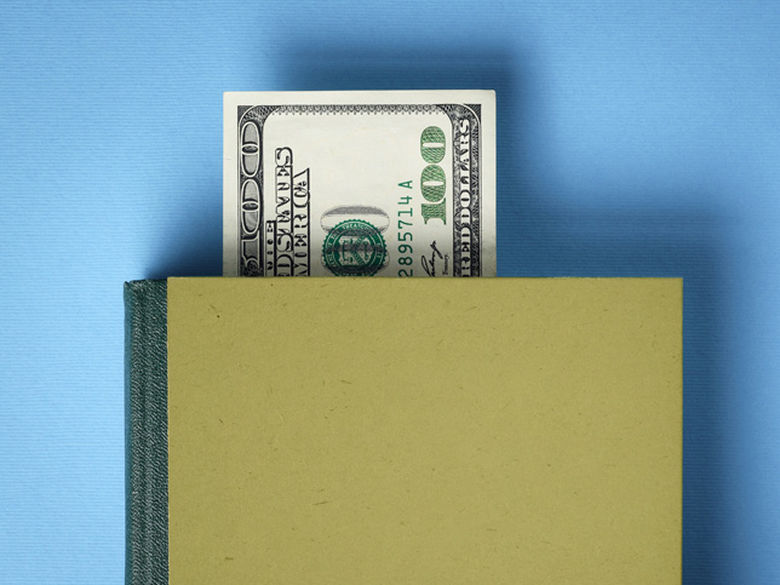 a hundred dollar bill sticking out of a book