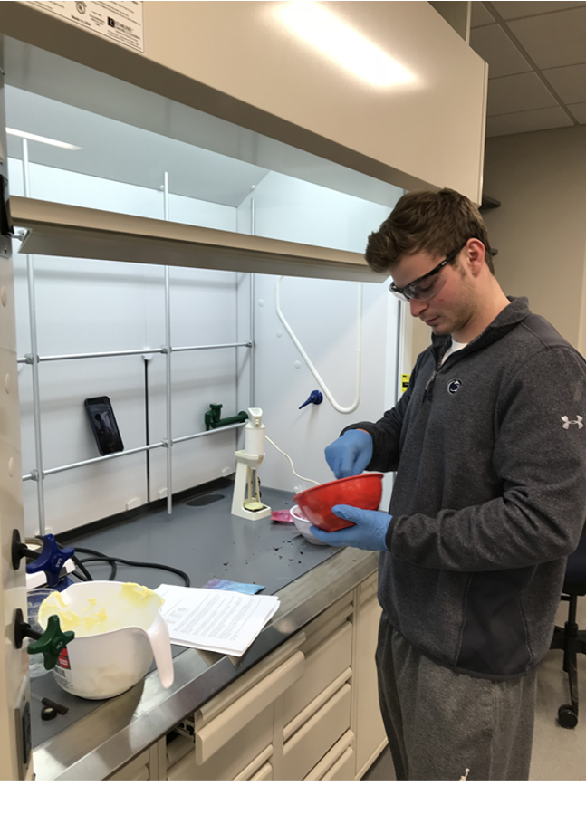 A young man in a lab working with soap