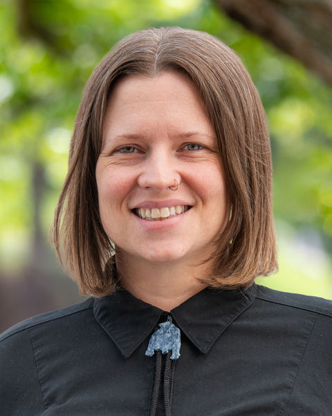 A photo of a woman wearing a black shirt and smiling