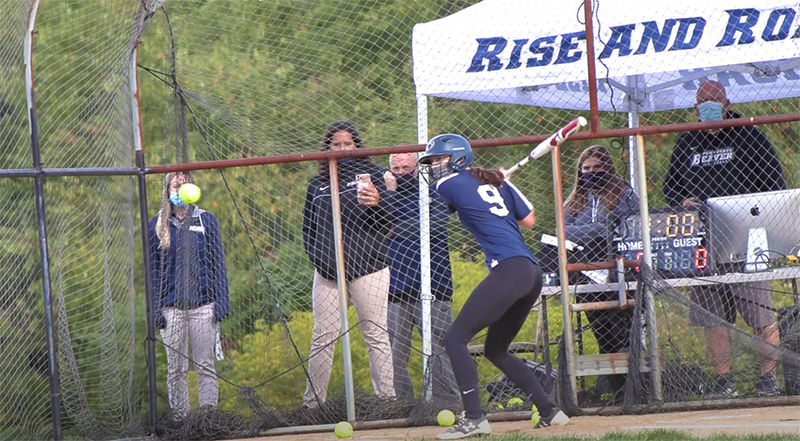 A female softball player stands at bat ready for a pitch.