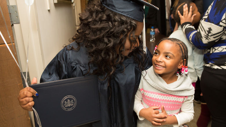 Graduate Taejsha McBride hugs her daughter.