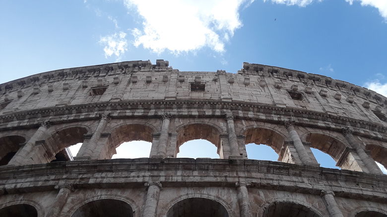 A view of the Colosseum against blue sky.