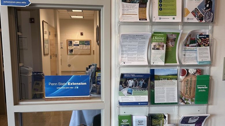 A photo of the Extension offices including a wall holder with various pamphlets and a sign that says Penn State Extension.