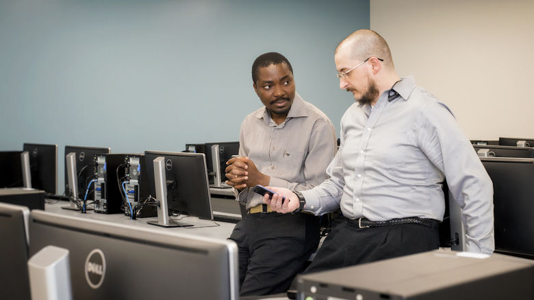 Beaver Professor Richard Lomotey and IST student Joe Pry confer in a computer lab.