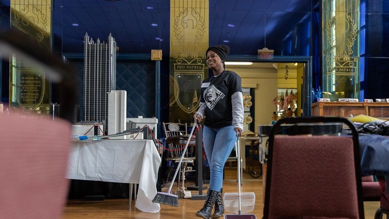 Student sweeps floor at museum