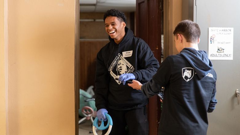 Student stands in doorway smiling