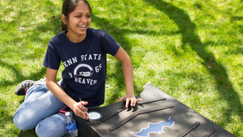 Ruhi Patel paints a bat house for the Beaver campus.