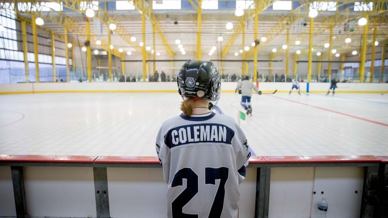 Forward Peri Coleman watches the hockey game from the bench.