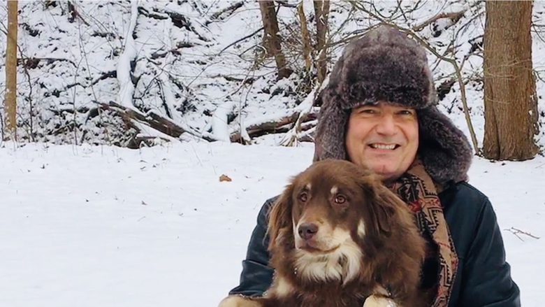Person holding a dog with snow visible in the background