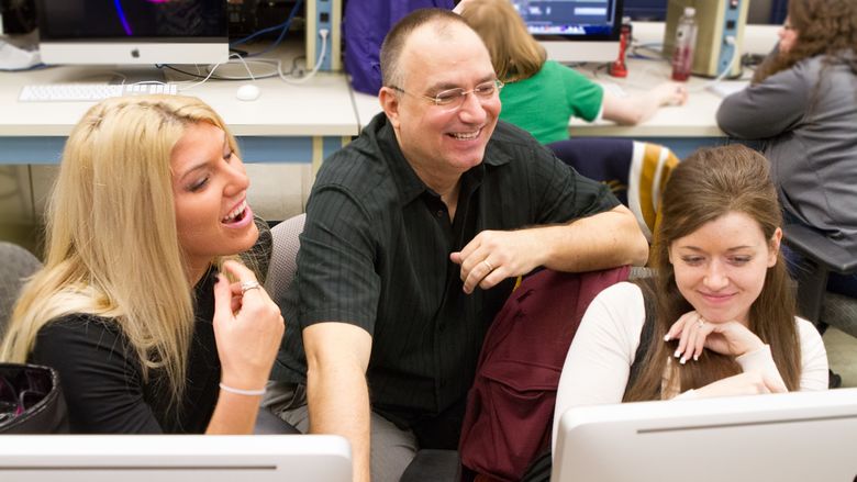 John Chapin and two students look at a computer screen.