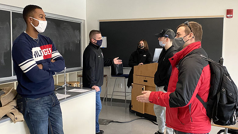 A group of former criminal justice students stand and talk to two Penn State Beaver students while the professor looks on