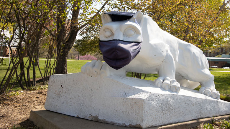Nittany Lion Shrine wearing a mask and mortarboard.