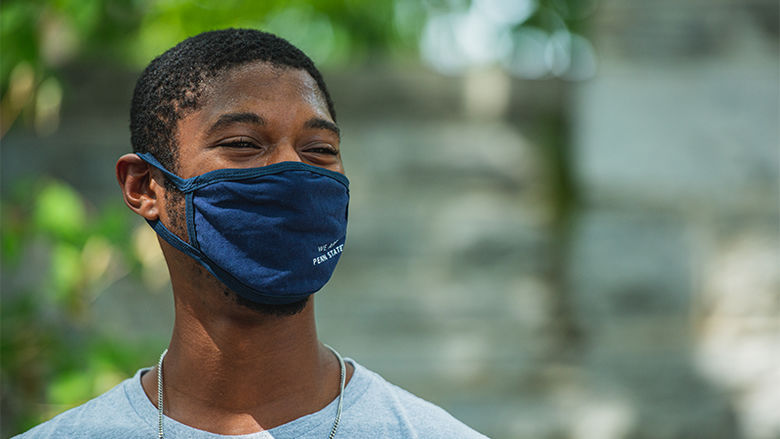 A young man wears a Penn State University face mask