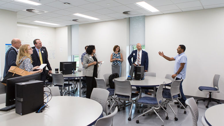 Instructor Ashu Kumar shows an IST classroom to a tour group.