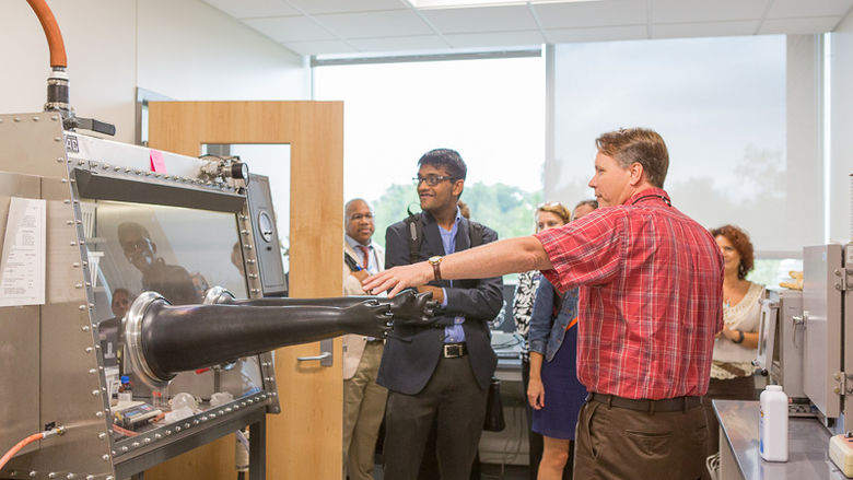 Michael Hay shows a tour group his chemistry equipment.