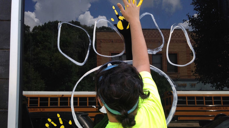 Sophomore Nick Pelino paints a handprint on a window.