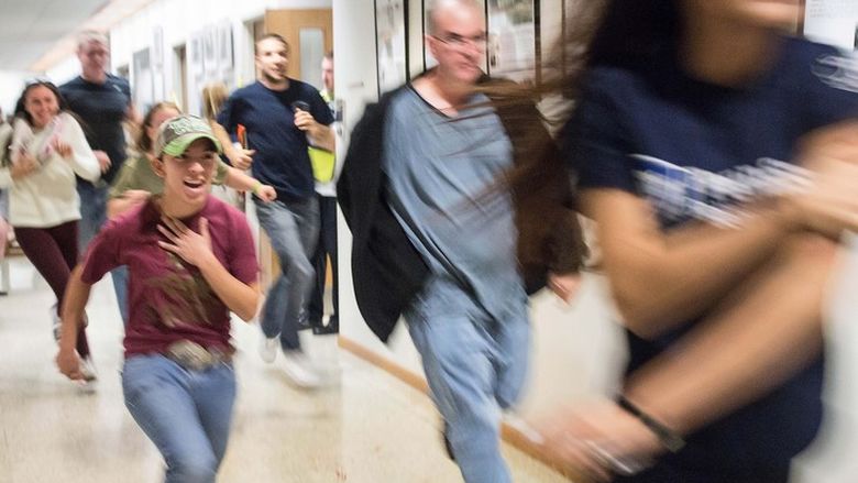 Student actors run down a hallway.