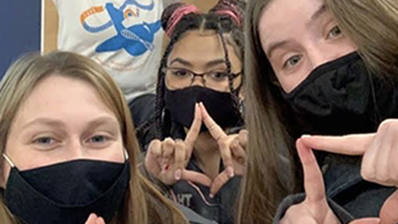 Five female student dancers wearing face masks pose before THON