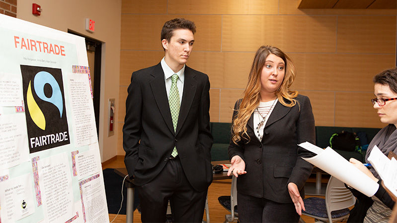 Two students present their project to judges.