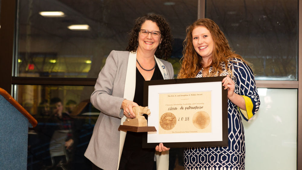 Chancellor Cushman hands Alexa Di Pietrantonio a framed certificate.