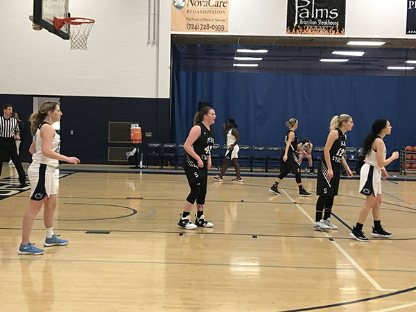 Women basketball players on the court in mid-play