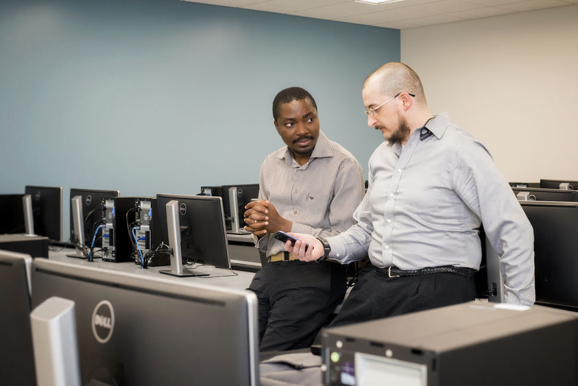 Beaver Professor Richard Lomotey and IST student Joe Pry confer in a computer lab.