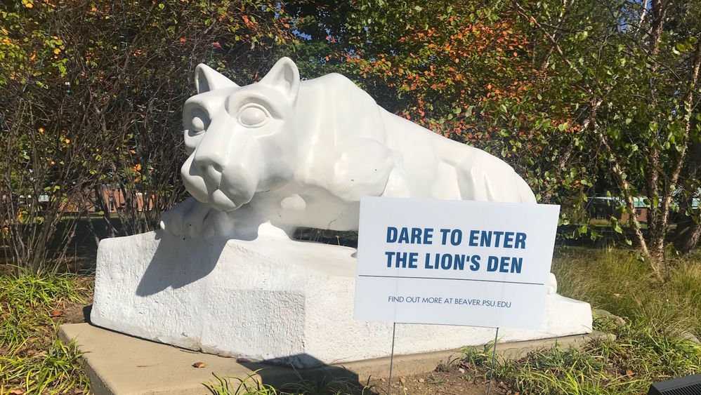 Dare to enter the Lion's Den sign sits in front of lion shrine.