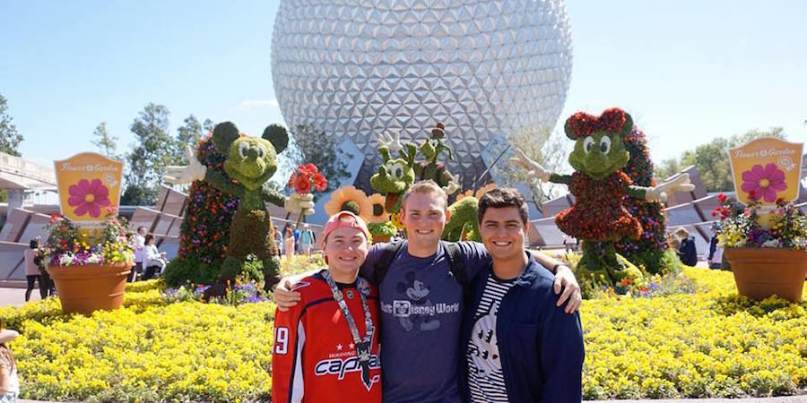 Nick Pelino and two of his roommates stand in front of a topiary display.