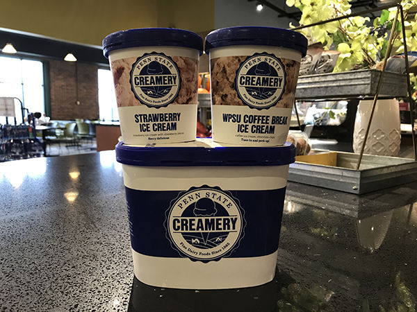 Cartons of Penn State ice cream are stacked up on a black countertop.