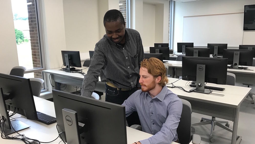 Richard Lomotey points to a computer as Evan McStay looks on.