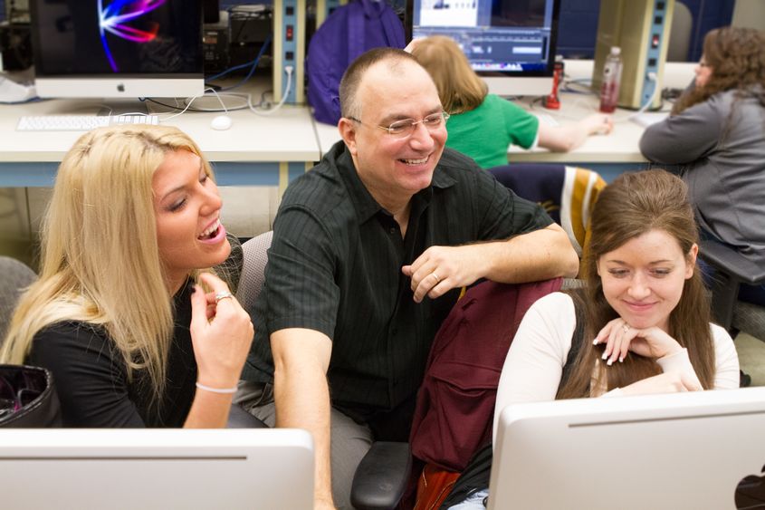 John Chapin and two students look at a computer screen.