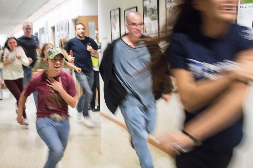 Students flee the building during an active shooter training drill at Penn State Beaver.