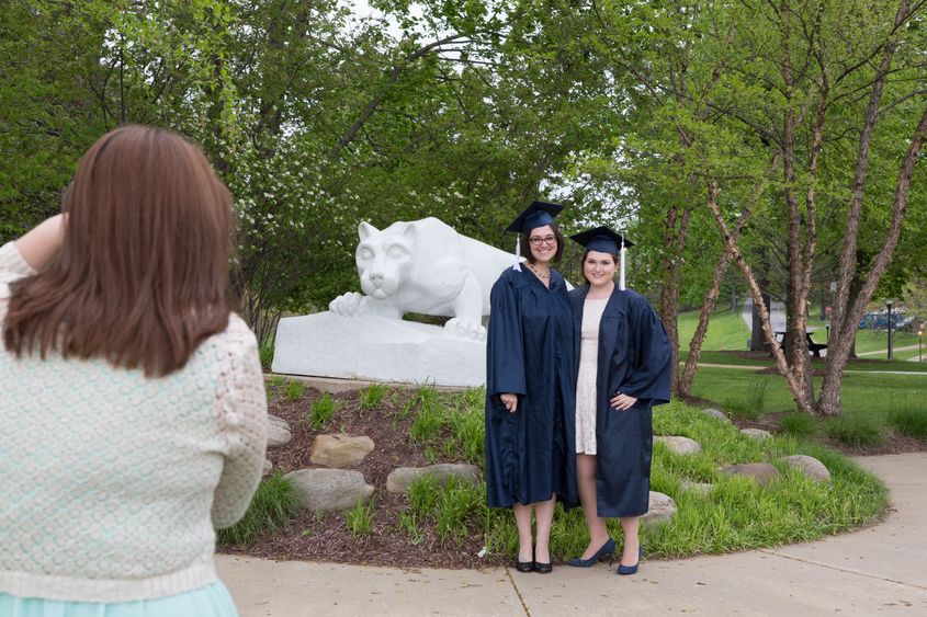 graduates posing at lion shrine